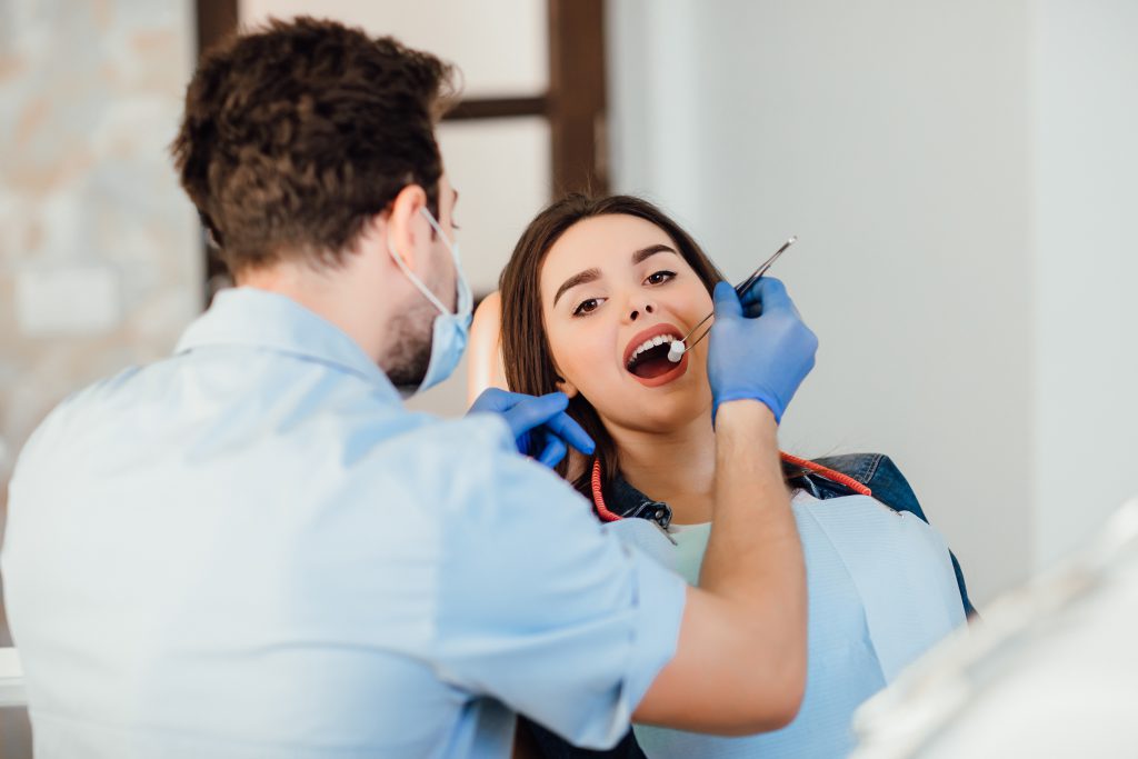 Dentysta Kraków – nowoczesny gabinet podczas badania jamy ustnej pacjenta.

