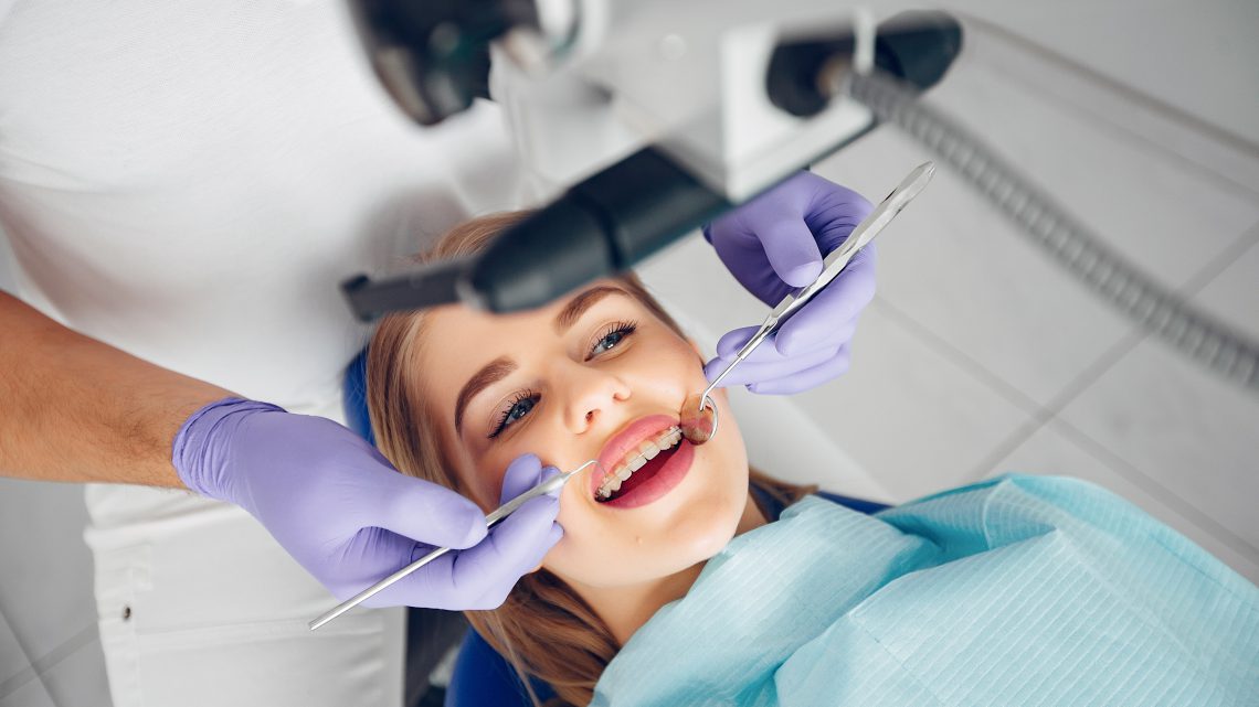 Profesjonalny dentysta w Krakowie wykonuje przegląd stomatologiczny.