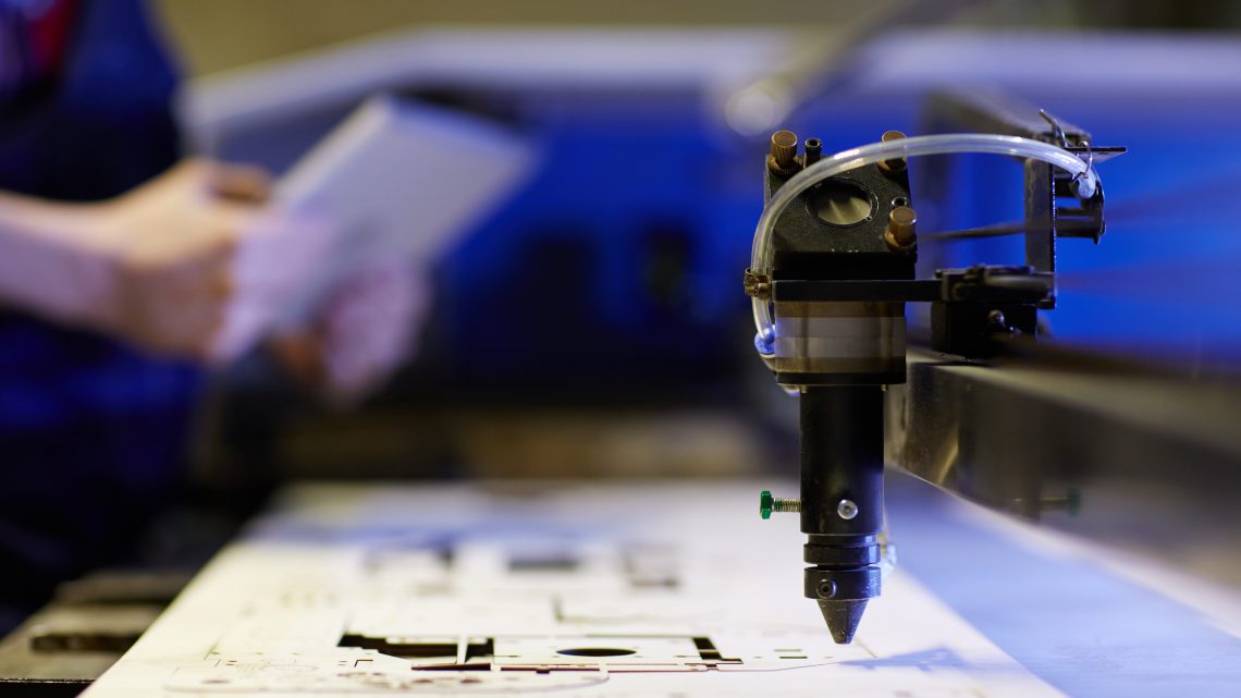 Głowica lasera tnącego podczas pracy w zakładzie przemysłowym – cięcie laserowe metalu