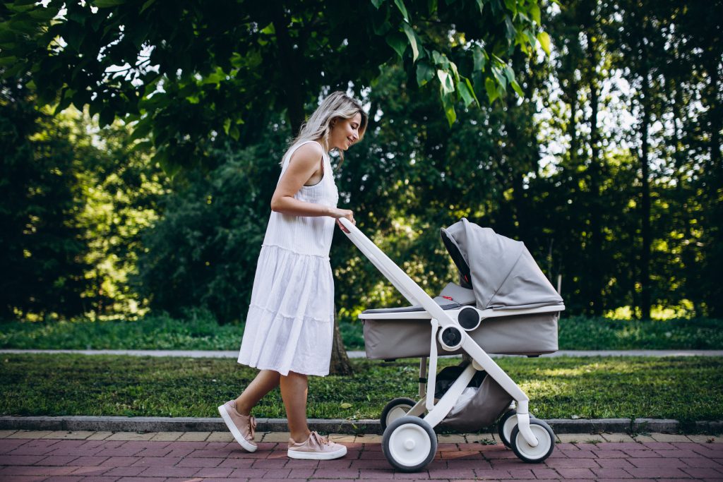 Wózek 2w1 - mama na spacerze z dzieckiem leżącym w wózku 2w1